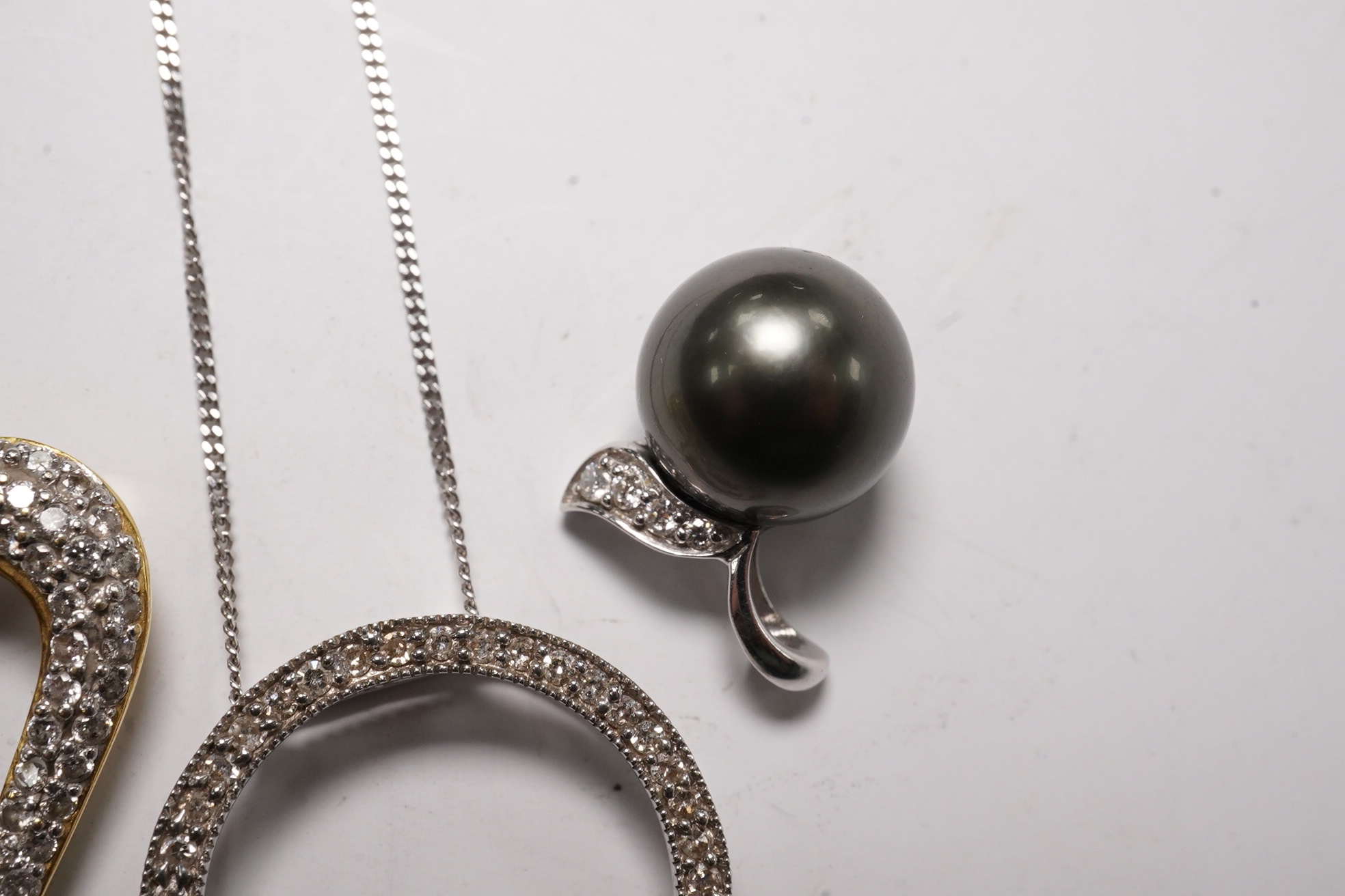 A modern 18k and diamond cluster set open work heart pendant, 25mm, a 9ct white gold and diamond chip set circular pendant necklace and o 9ct and Tahitian cultured pearl set pendant. Condition - fair to good